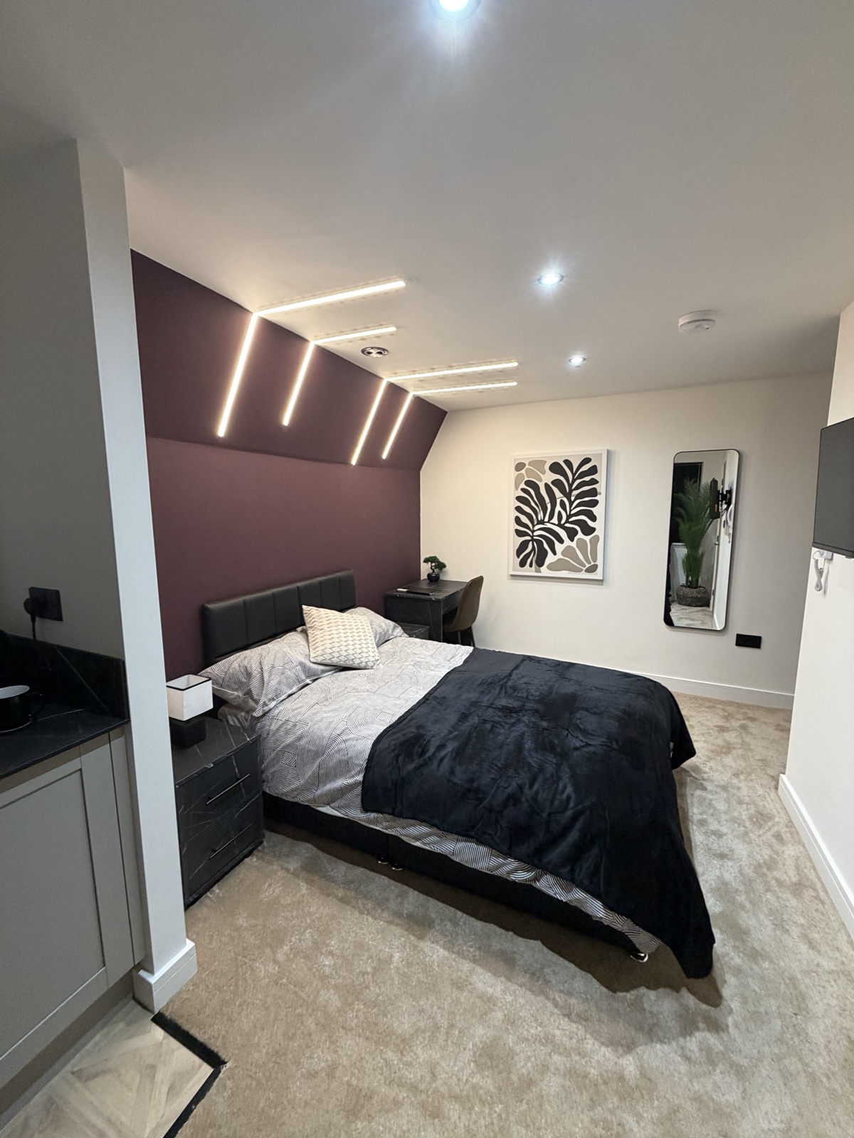 A double bedroom we manage in the North East, with a burgundy feature wall and modern LED lighting