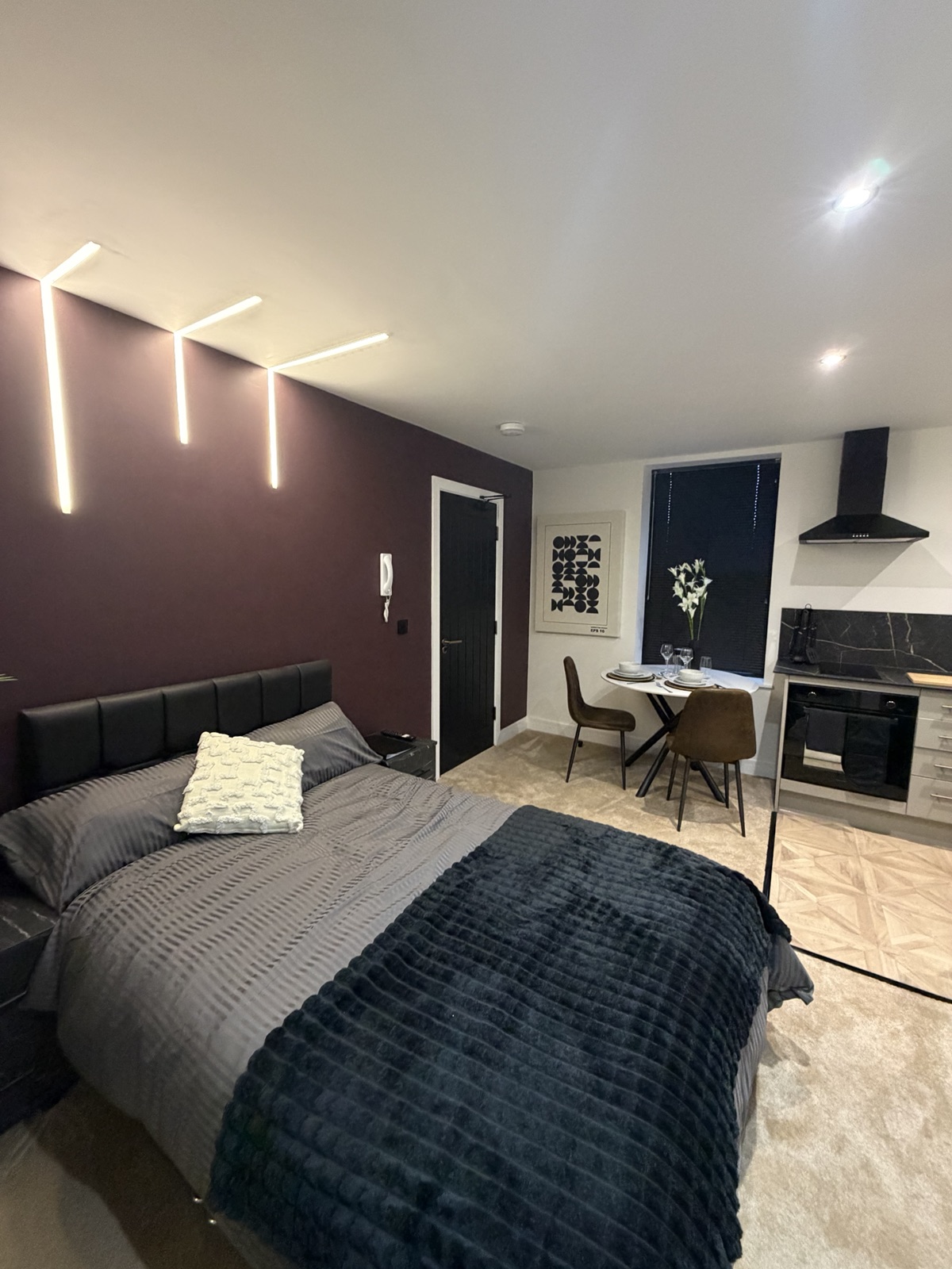A managed studio room with feature wall lighting and open-plan living space